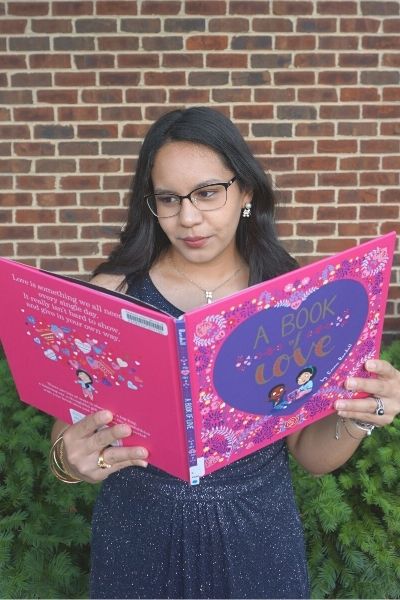 Yasmin reading "A book of love", one of our suggested picture books to read for Valentine's Day | Children's Book for Valentine's Day